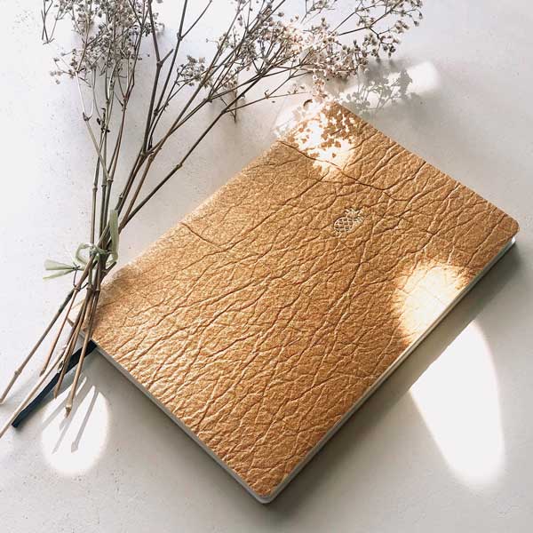 nachhaltiges, edles Notizbuch aus veganem Leder. Das Notizbuch wurde in der Schweiz hergestellt und handgefertigt. Das nachhaltige Notizbuch A5 ist aus Ananasleder und hat die Farbe gold.